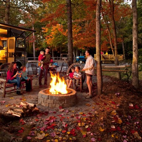 people smiling around a fire ring