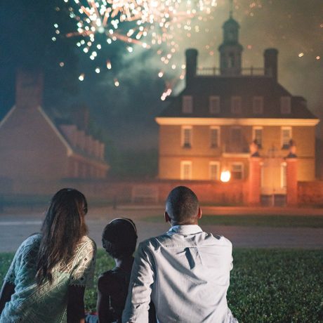 people camped out on picnic blanket watching fireworks