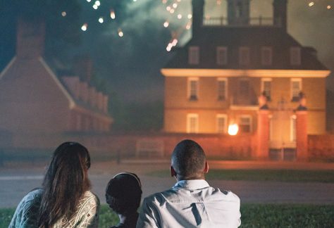 people camped out on picnic blanket watching fireworks