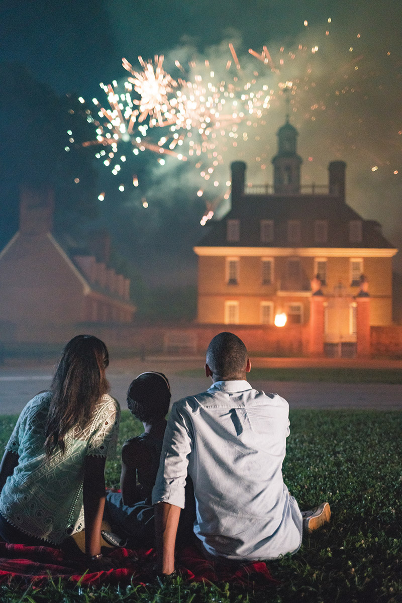 people camped out on picnic blanket watching fireworks