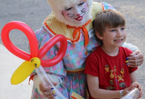 kid smiling with woman in easter bunny costume