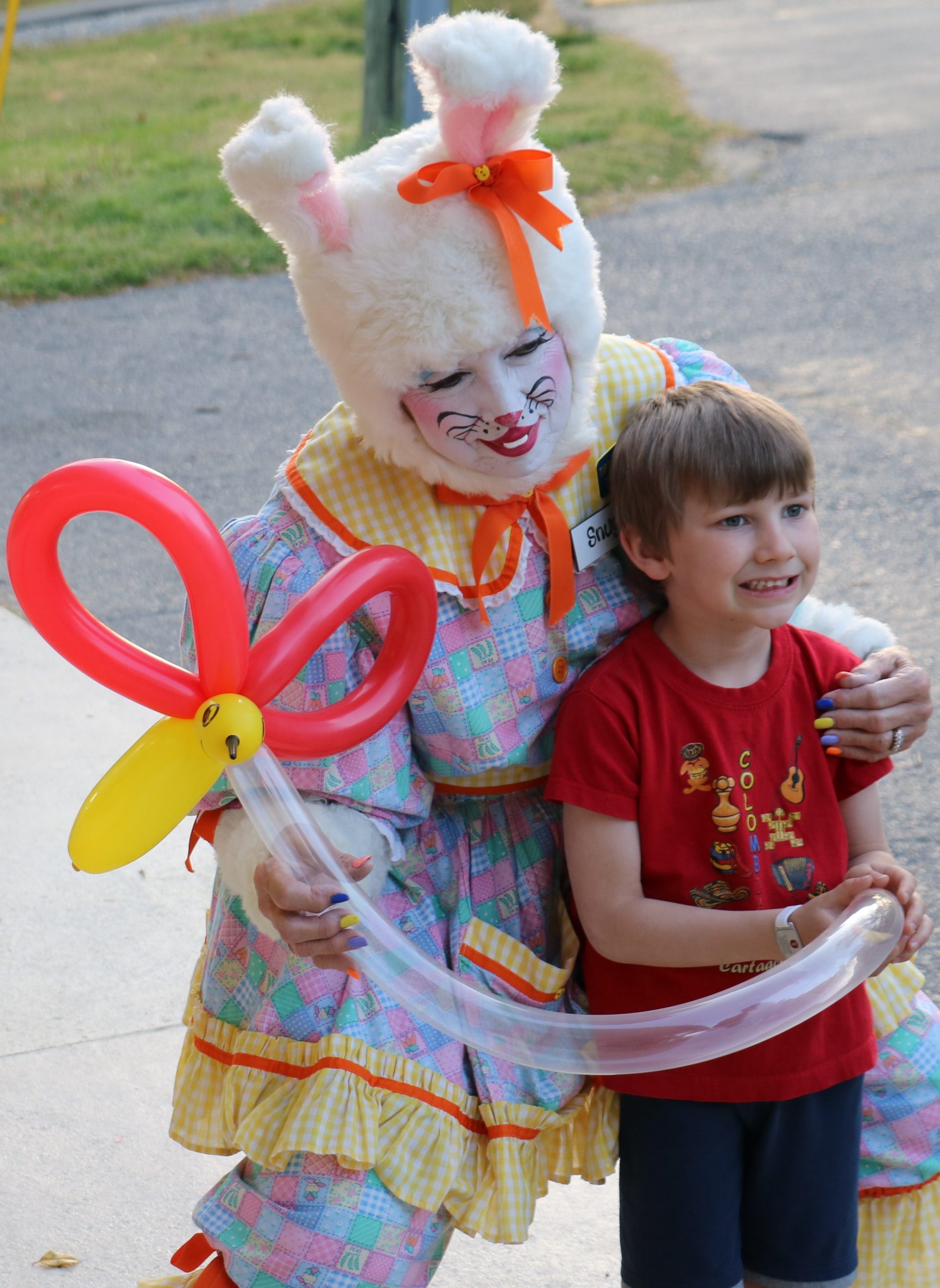 kid smiling with woman in easter bunny costume