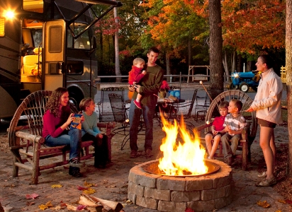 people smiling around a fire ring