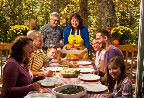 people smiling around table for thanksgiving dinner