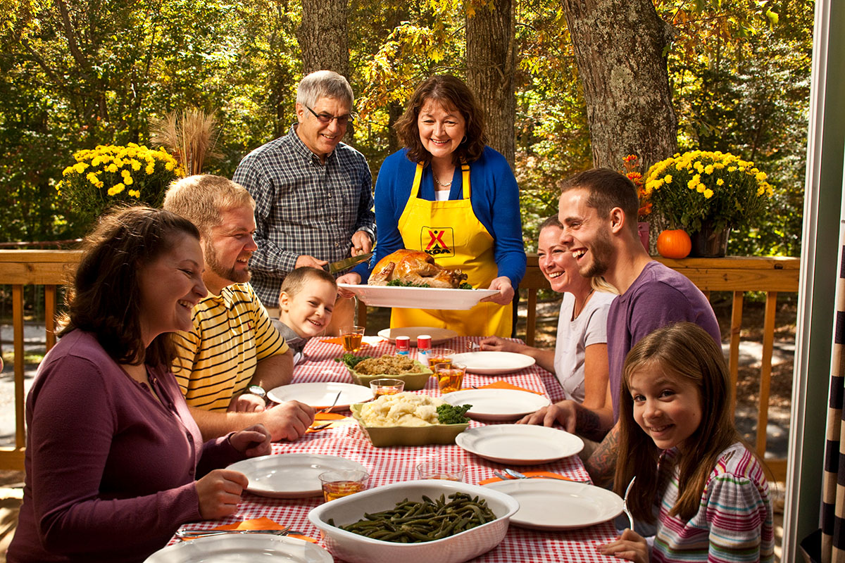 people smiling around table for thanksgiving dinner