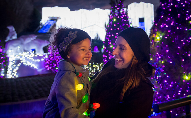 mother and child smiling near christmas decorations