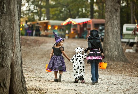 kids in halloween costumes walking away from camera