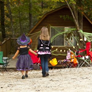 kids in halloween costumes walking toward cabin