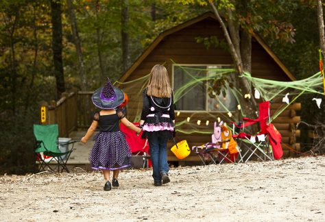 kids in halloween costumes walking toward cabin