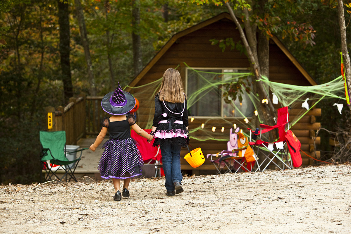 kids in halloween costumes walking toward cabin